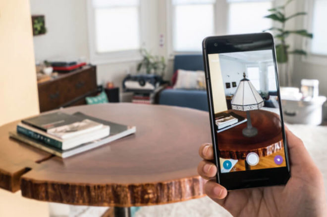 A phone screen showing a 3D lamp placed on a real table through augmented reality
